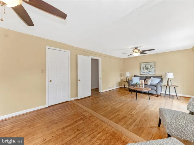a living room with furniture and dining table with wooden floor