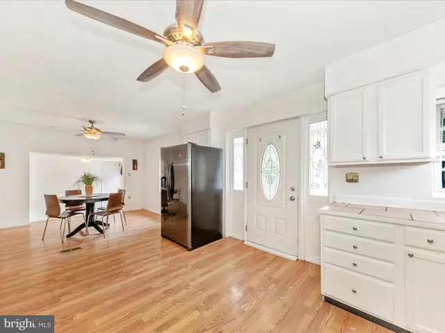 a kitchen with stainless steel appliances kitchen island granite countertop a refrigerator and cabinets