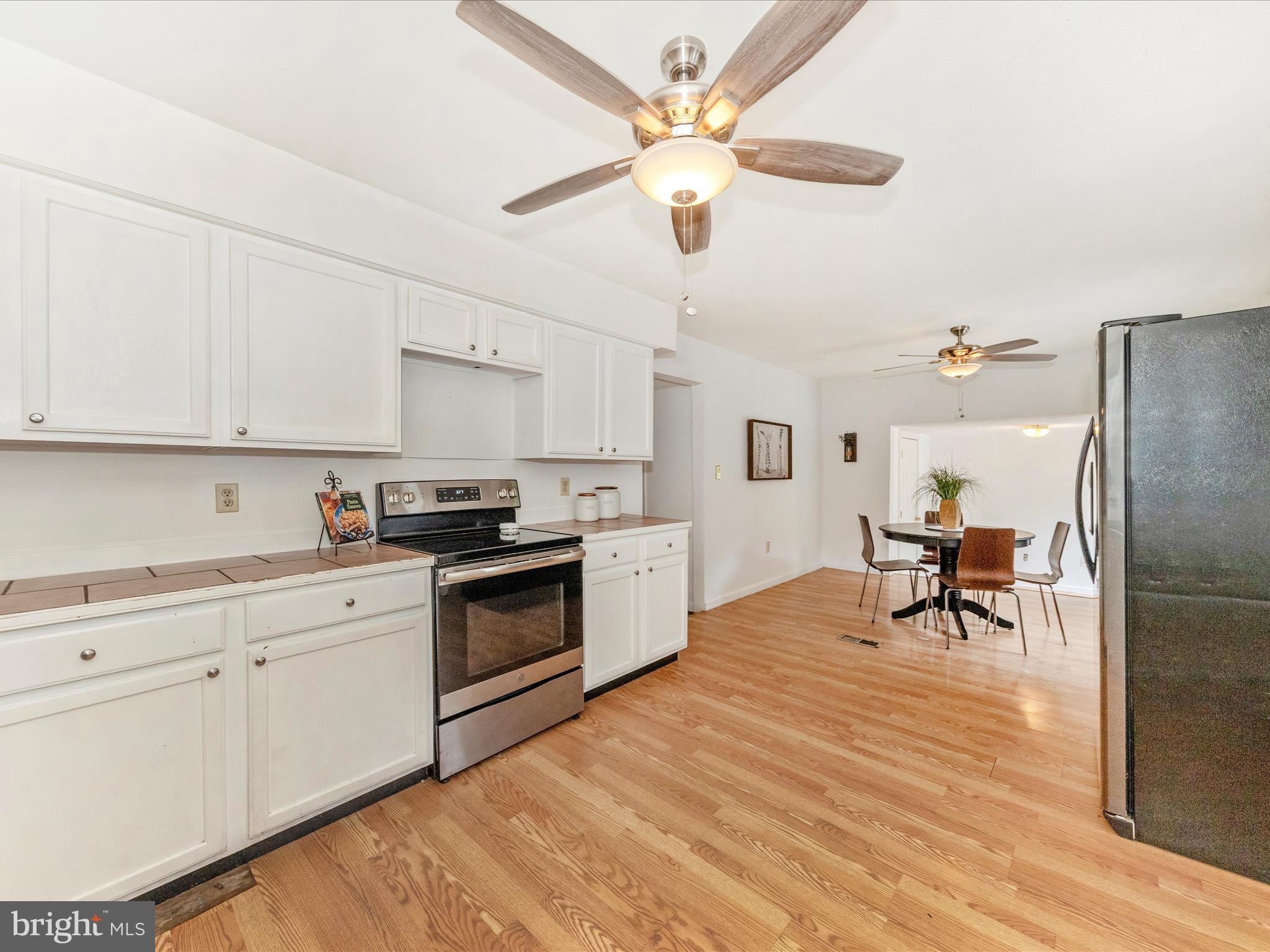 6 Myers Trail Berkeley Springs, WV 25411 - Photo 6 of 39 a kitchen with stainless steel appliances white cabinets and wooden floor