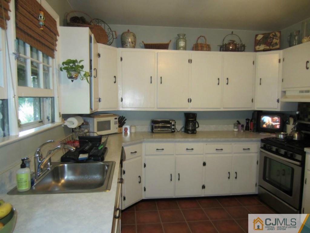4 Edgebrook Road New Brunswick, NJ 08901 - Photo 7 of 22 a kitchen with stainless steel appliances granite countertop a sink stove and cabinets