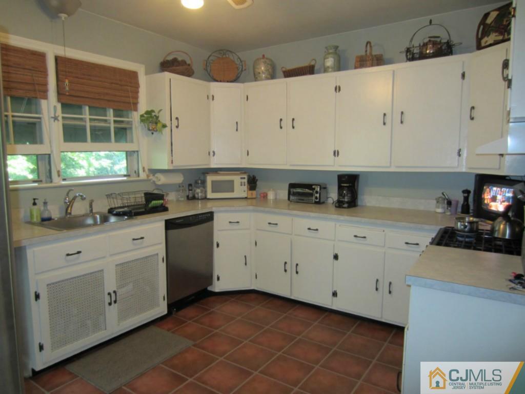 4 Edgebrook Road New Brunswick, NJ 08901 - Photo 8 of 22 a kitchen with cabinets appliances a sink and a window