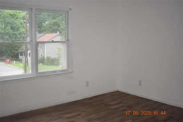 an empty room with wooden floor and a window