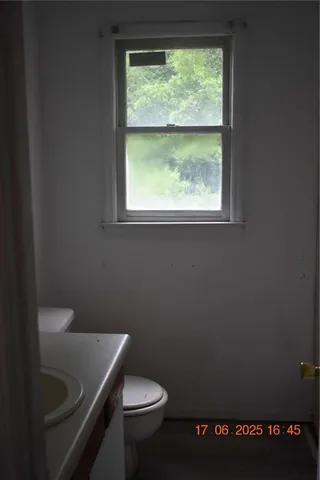 a bathroom with a toilet sink and window