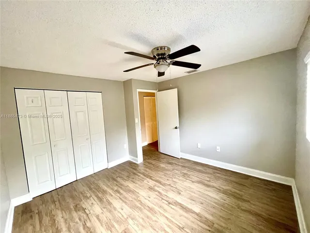 a view of a livingroom with a ceiling fan and wooden floor