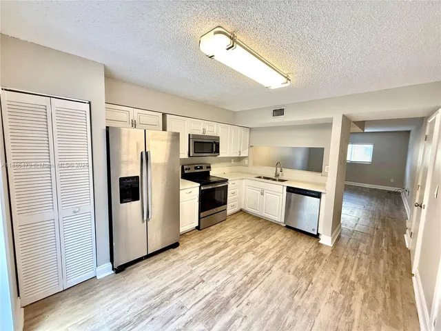 a kitchen with white cabinets and white appliances