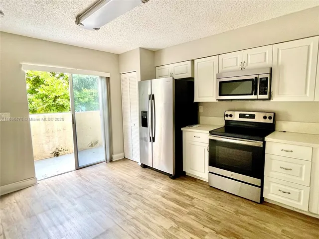 a kitchen with stainless steel appliances a stove microwave and refrigerator