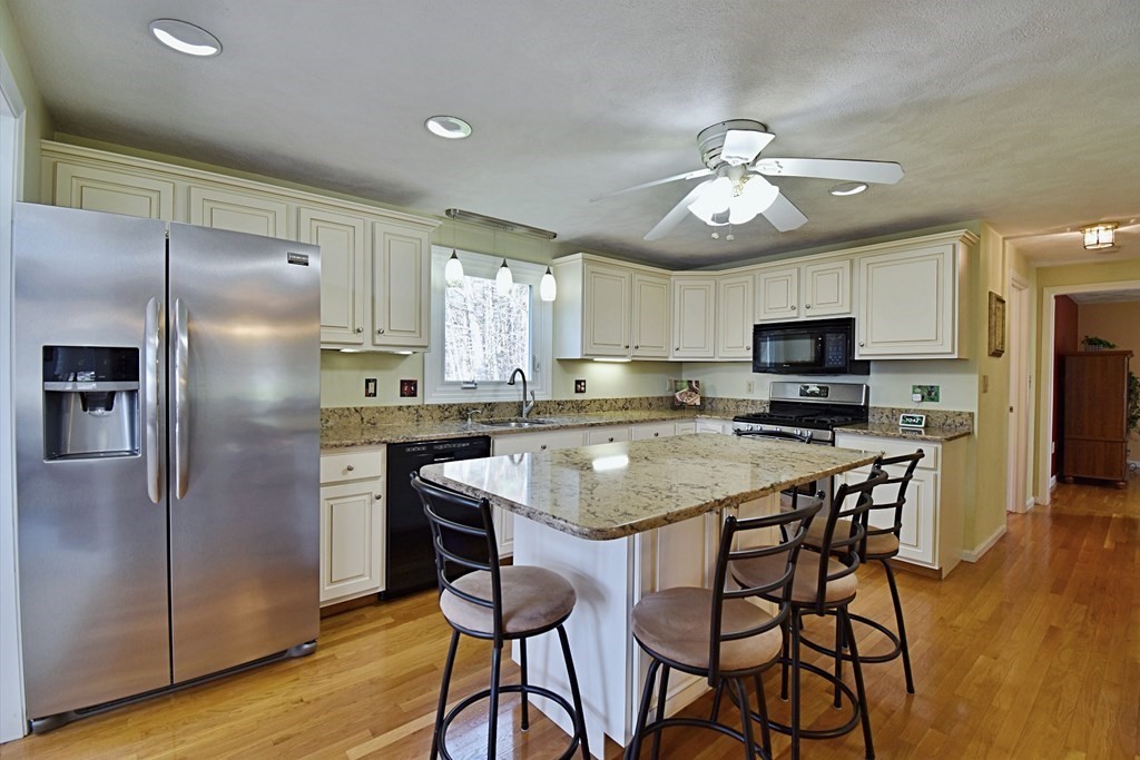 9 Chard Road Tyngsborough, MA 01879 - Photo 3 of 38 a kitchen with stainless steel appliances granite countertop a refrigerator a sink dishwasher a stove and white countertops with wooden floor