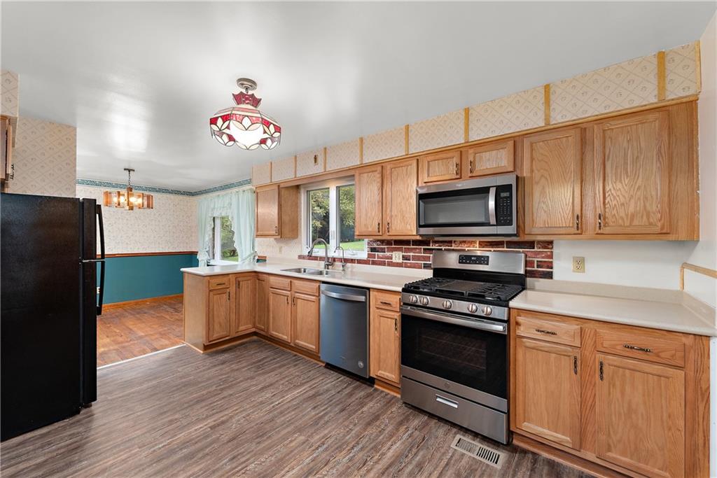 110 Forresta Drive Butler, PA 16002 - Photo 8 of 25 a kitchen with granite countertop wooden floors stainless steel appliances and sink