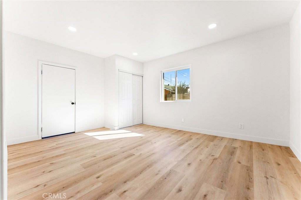 10872 Flower Avenue Stanton, CA 90680 - Photo 18 of 26 an empty room with wooden floor and windows