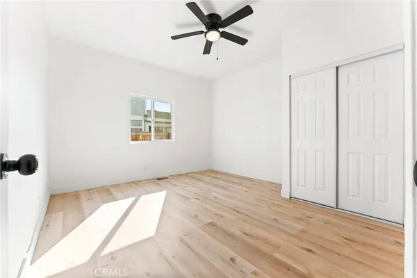 a view of an empty room with a window and a ceiling fan