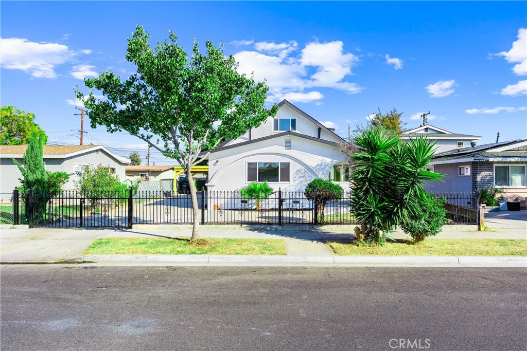 a view of a house with palm trees and a small yard