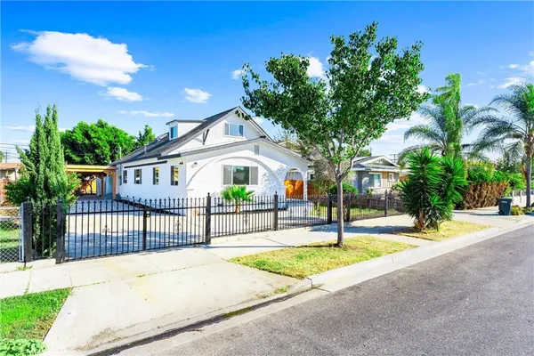 a view of an house with backyard and a tree