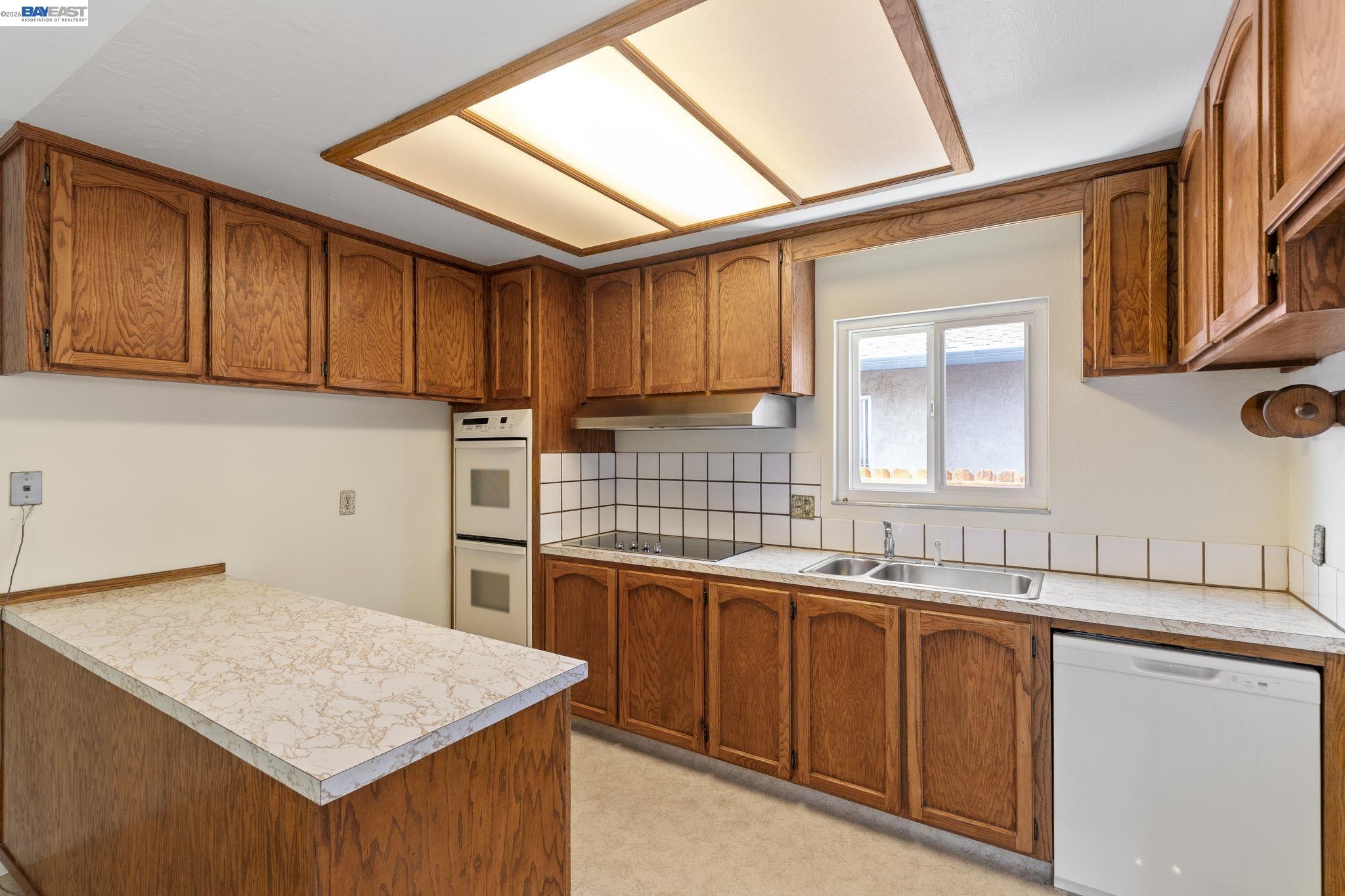 40272 Davis Street Fremont, CA 94538 - Photo 9 of 46 a kitchen that has a sink and a stove in it