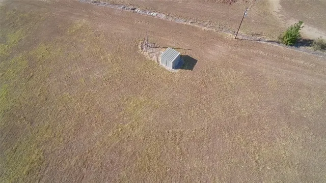 a view of a livingroom with furniture a fireplace wooden floor and windows