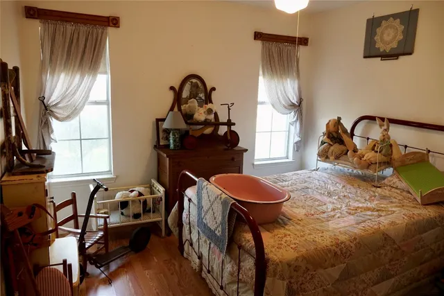 a bedroom with a bed a mirror on the dresser and a chandelier