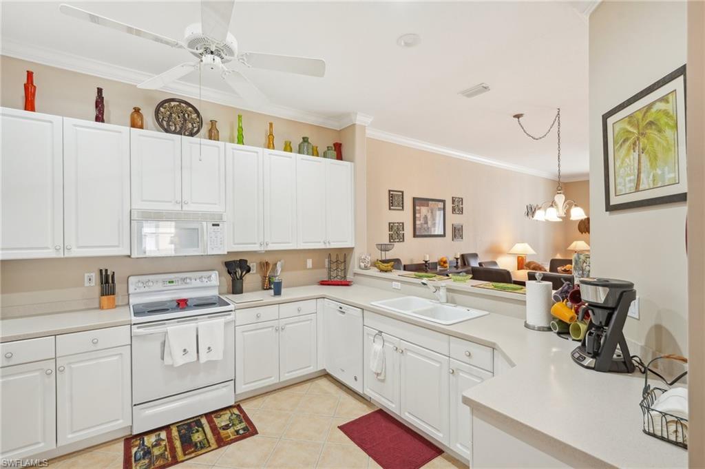 3553 Periwinkle Way Naples, FL 34114 - Photo 13 of 43 Kitchen with ornamental molding, a sink, white cabinetry, light countertops, and white appliances