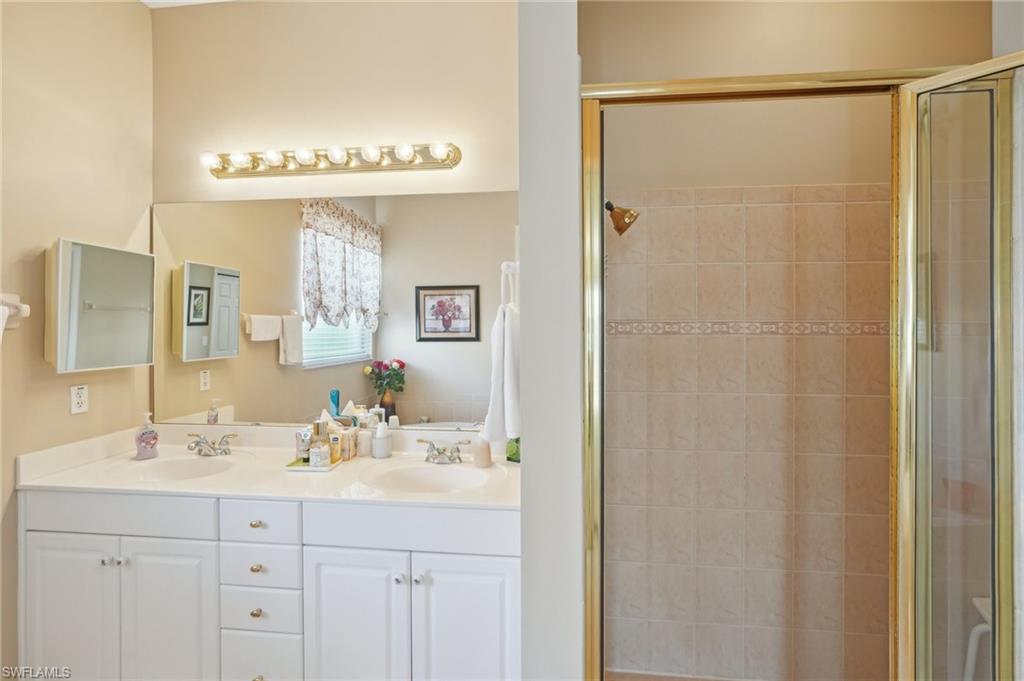 3553 Periwinkle Way Naples, FL 34114 - Photo 28 of 43 Bathroom featuring a sink, double vanity, and a shower stall