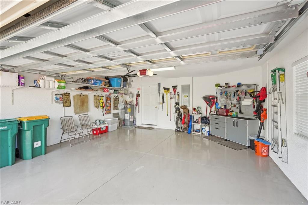 3553 Periwinkle Way Naples, FL 34114 - Photo 30 of 43 Garage featuring electric panel, a garage door opener, and water heater