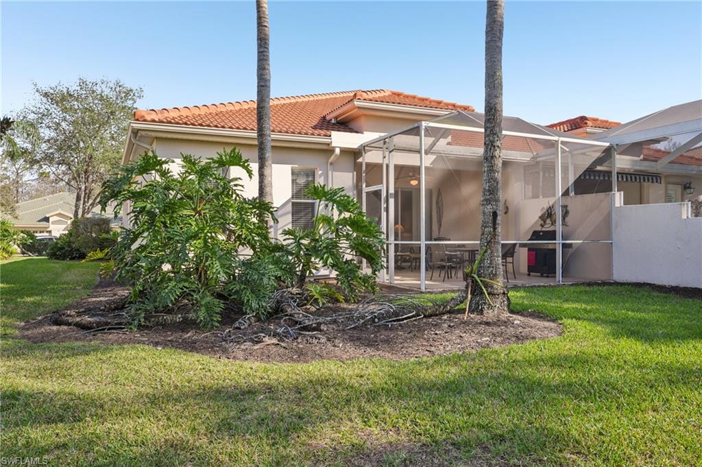 3553 Periwinkle Way Naples, FL 34114 - Photo 34 of 43 Back of house with a lanai, a lawn, a patio area, and a tile roof