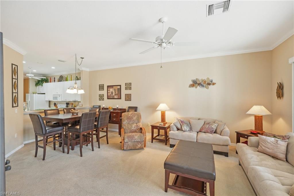 3553 Periwinkle Way Naples, FL 34114 - Photo 6 of 43 Living area featuring light colored carpet, crown molding, visible vents, baseboards, and ceiling fan