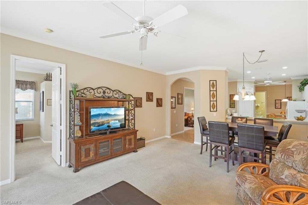 3553 Periwinkle Way Naples, FL 34114 - Photo 7 of 43 Living room featuring arched walkways, light carpet, and crown molding