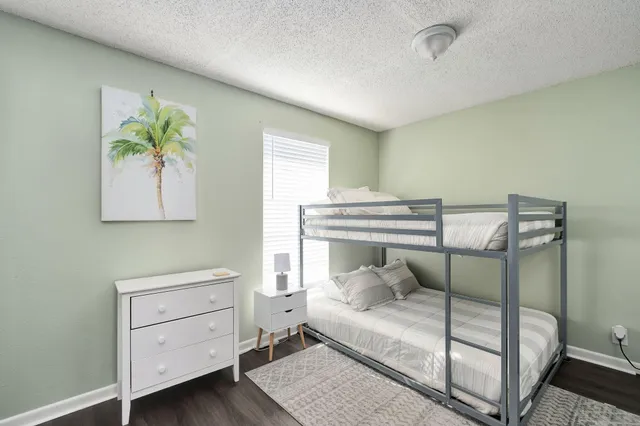 a bedroom with a bed and a painting on the wall