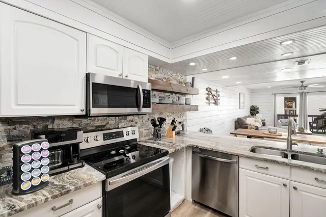 a kitchen with stainless steel appliances a stove a sink and a microwave