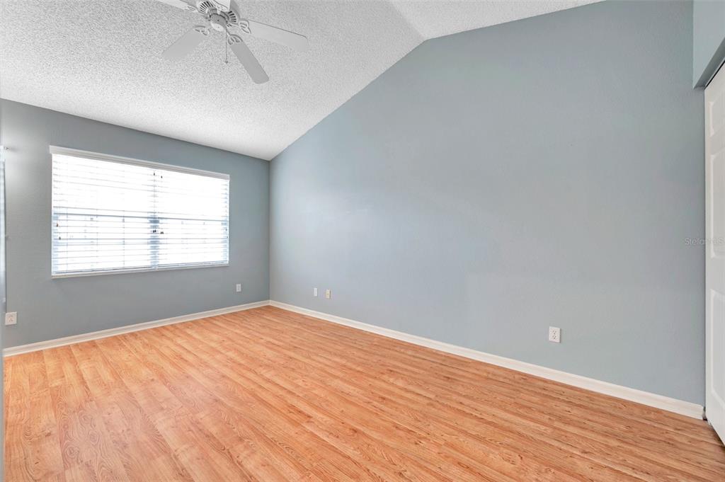 2739 Enterprise Road East, Unit 1 Clearwater, FL 33759 - Photo 11 of 20 an empty room with wooden floor chandelier fan and windows