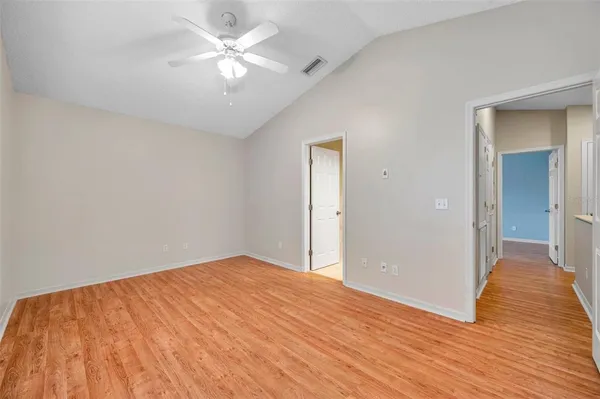a view of a big room with wooden floor and a chandelier fan