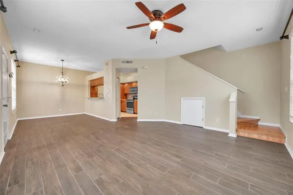 a view of a room with wooden floor and a ceiling fan