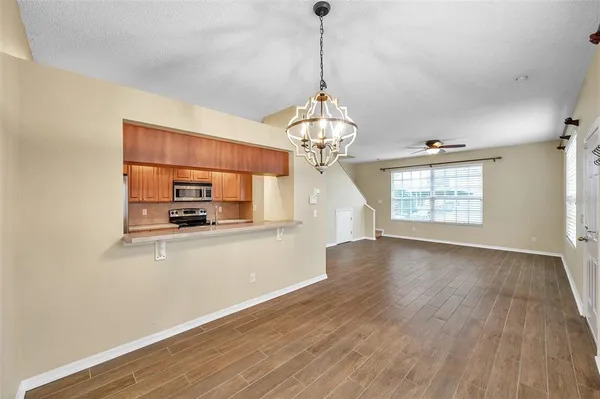 a view of a room with wooden floor windows and a chandelier