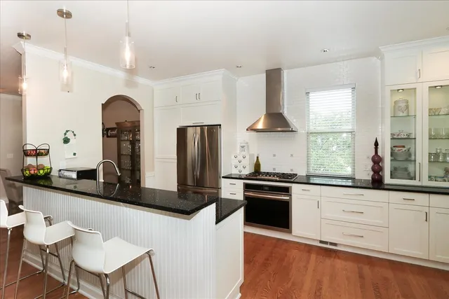 a kitchen with granite countertop white cabinets and stainless steel appliances