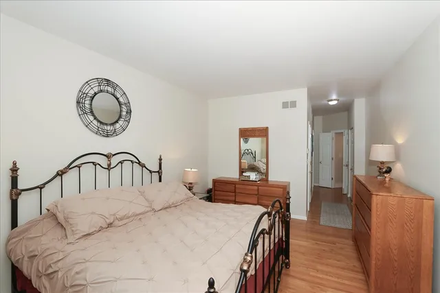 a bedroom with a bed and a table with wooden floor