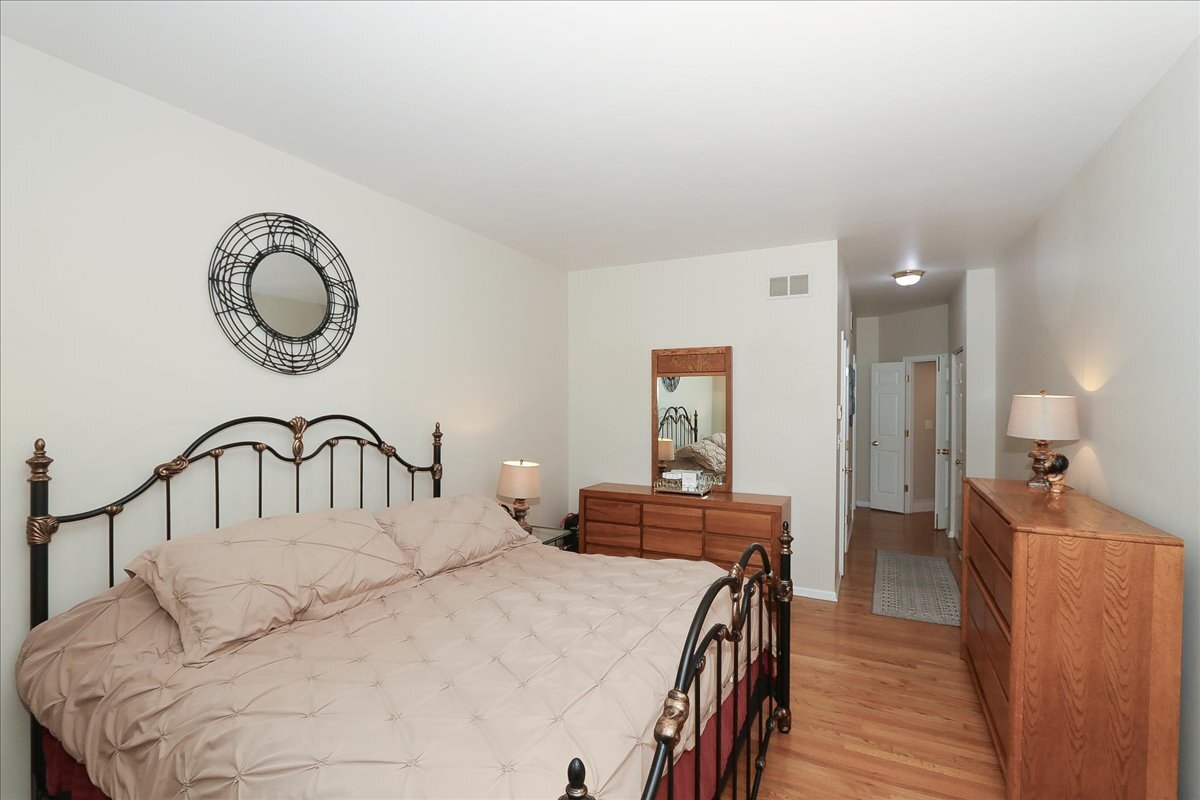 768 St Johns Place Addison, IL 60101 - Photo 23 of 39 a bedroom with a bed and a table with wooden floor