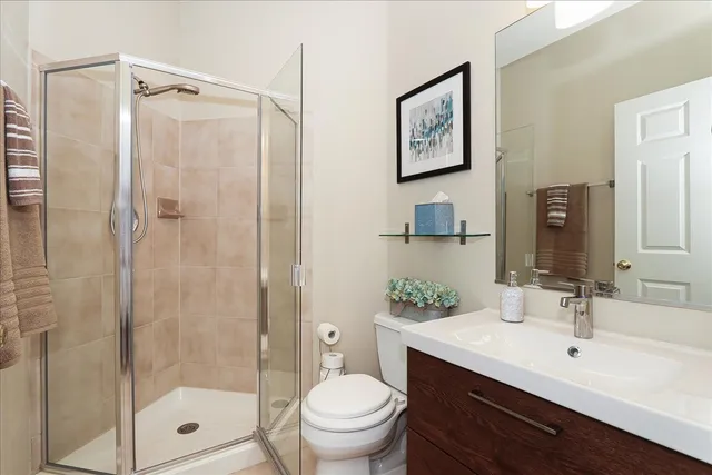 a bathroom with a shower sink vanity mirror and toilet