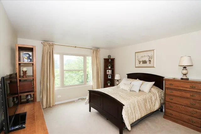 a bedroom with a bed and a flat tv screen on a dresser