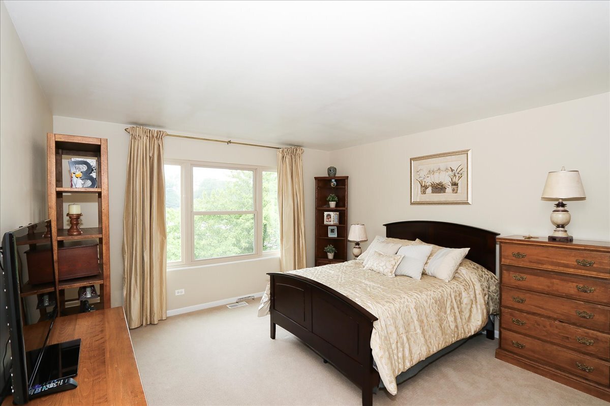 768 St Johns Place Addison, IL 60101 - Photo 30 of 39 a bedroom with a bed and a flat tv screen on a dresser