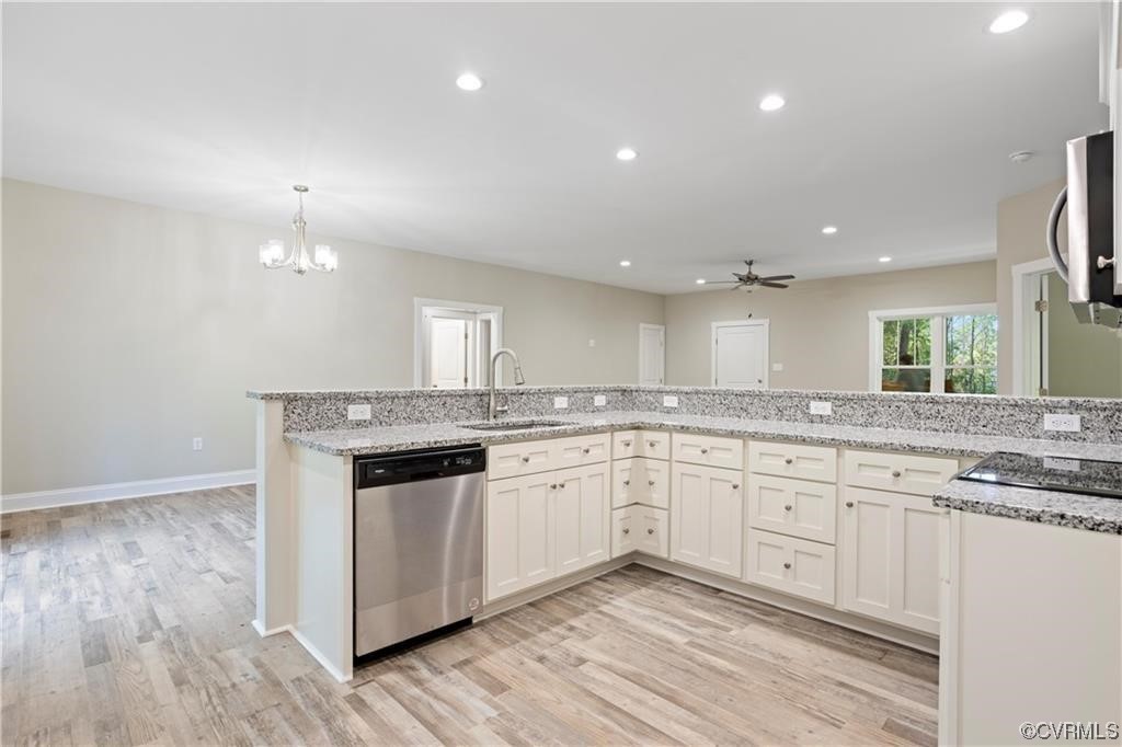 3734 Fredericks Hall Road Mineral, VA 23117 - Photo 5 of 9 a large kitchen with granite countertop a stove top oven a sink and white cabinets with wooden floor