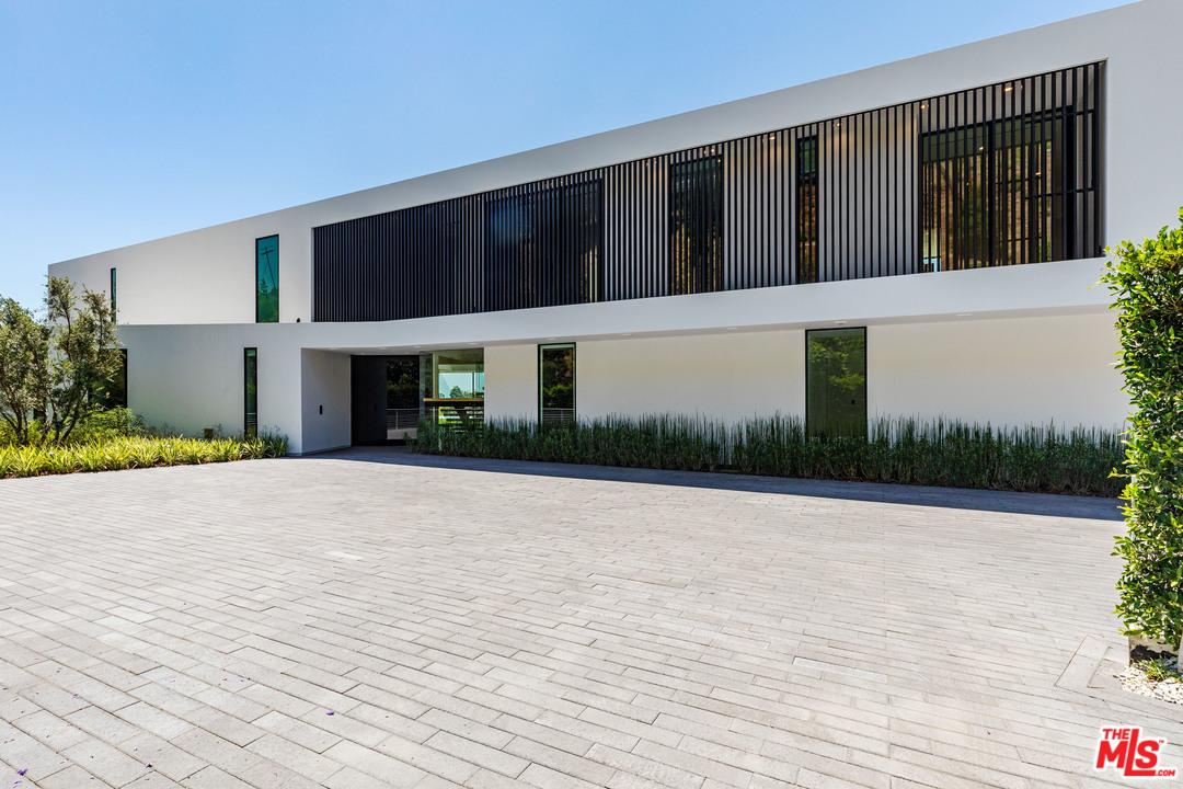 1259 Beverly Estate Drive Beverly Hills, CA 90210 - Photo 4 of 43 a front view of a house with a yard and garage