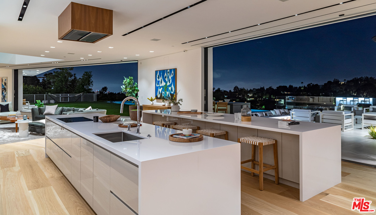 1259 Beverly Estate Drive Beverly Hills, CA 90210 - Photo 35 of 43 a kitchen with stainless steel appliances kitchen island a large counter top space a sink and living room view