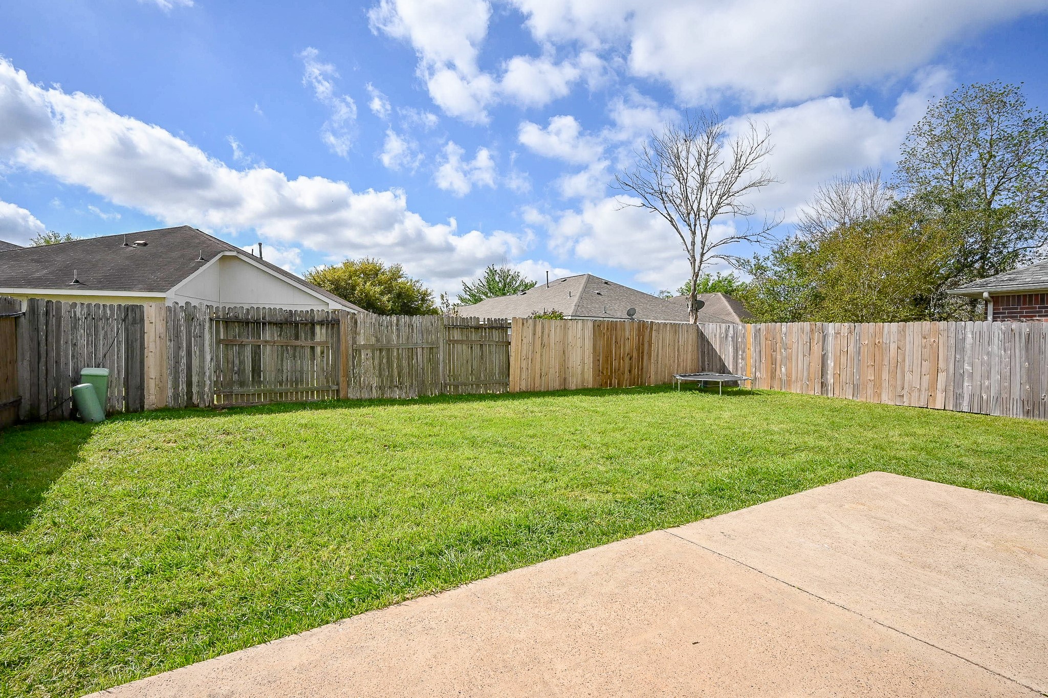 2534 Halstead Drive Spring, TX 77386 - Photo 33 of 35 Enjoy this spacious backyard with a well-maintained lawn, surrounded by a wooden fence for privacy. The area includes a patio space, ideal for outdoor activities and relaxation.