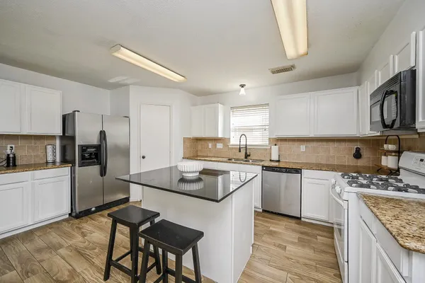 a kitchen with stainless steel appliances granite countertop a stove refrigerator sink and cabinets