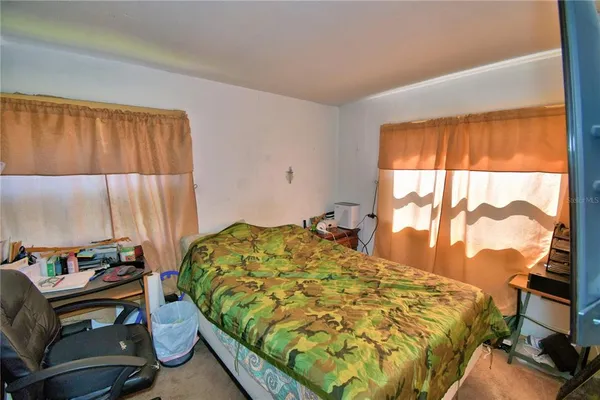 a view of swimming pool with lawn chairs and plants