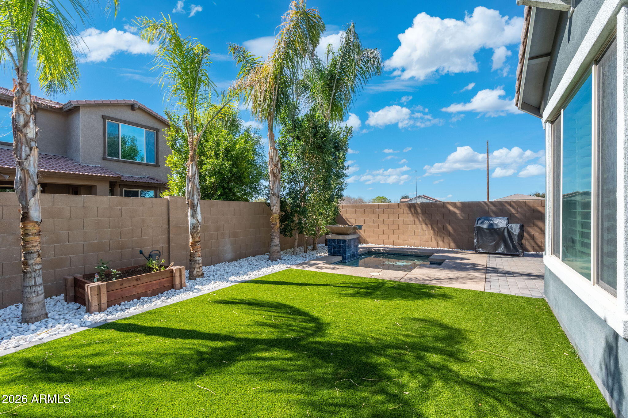 4041 East Amber Lane Gilbert, AZ 85296 - Photo 31 of 31 a backyard of a house with table and chairs floor to ceiling window and potted plants