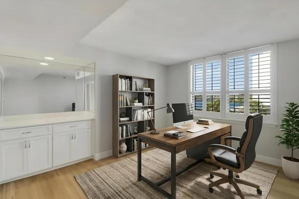 a view of a workspace with furniture and a window