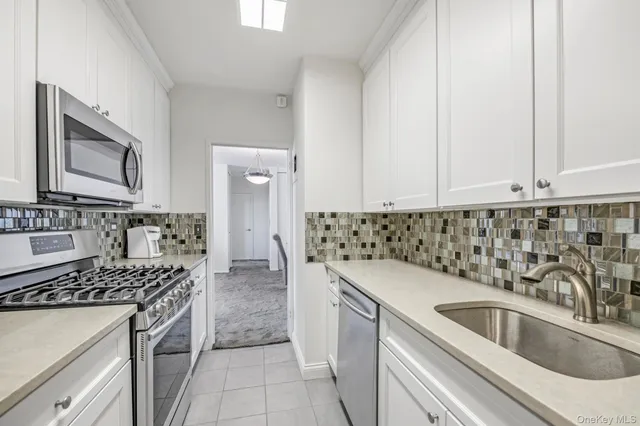 a kitchen with sink a stove and cabinets