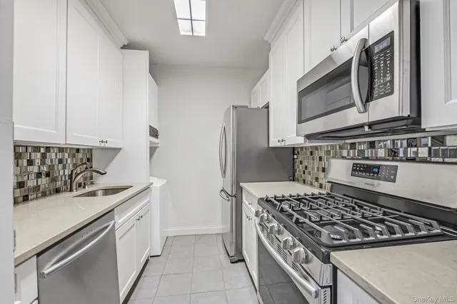 a kitchen with stainless steel appliances granite countertop a stove and a microwave