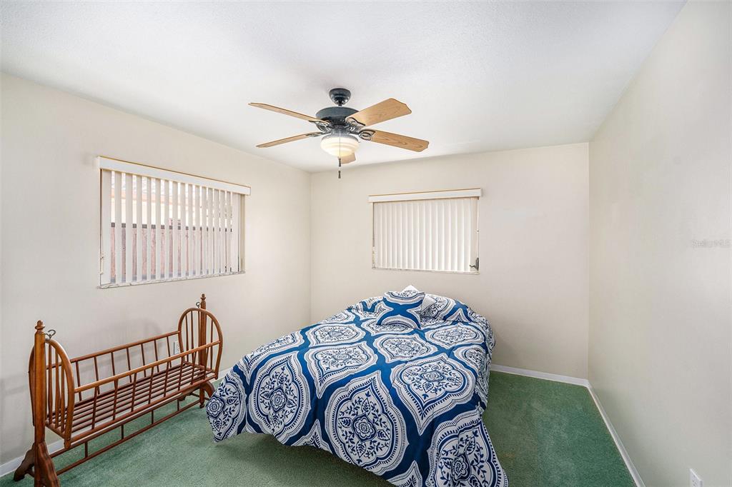 10400 112th Way Largo, FL 33778 - Photo 20 of 30 a bedroom with a bed and a chandelier