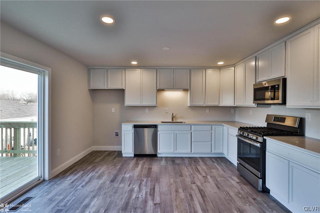647 Sipos Drive Northampton, PA 18067 - Photo 17 of 47 a kitchen with granite countertop wooden floors stainless steel appliances and sink