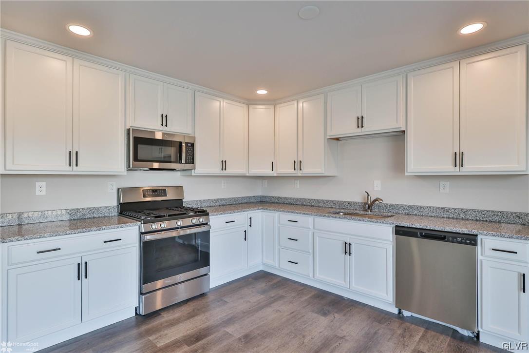 647 Sipos Drive Northampton, PA 18067 - Photo 9 of 47 a kitchen with granite countertop white cabinets white stainless steel appliances with a sink and dishwasher